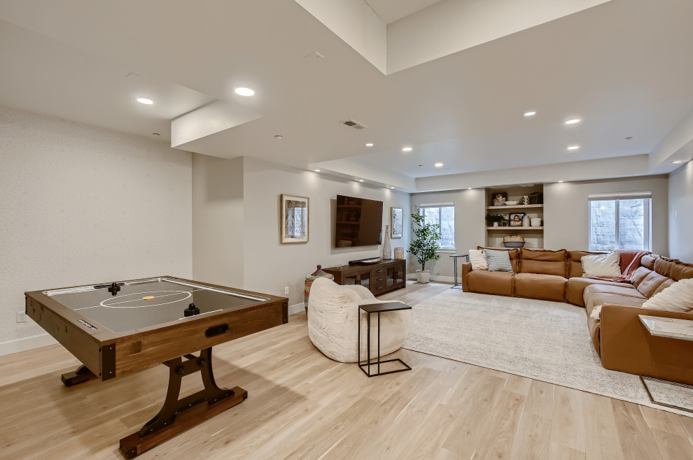 Photo of a large mediterranean look-out basement in Denver with grey walls, laminate floors and grey floors.