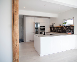 Gesamteindruck der offenen Küche mit Blick auf die integrierte Speisekammer