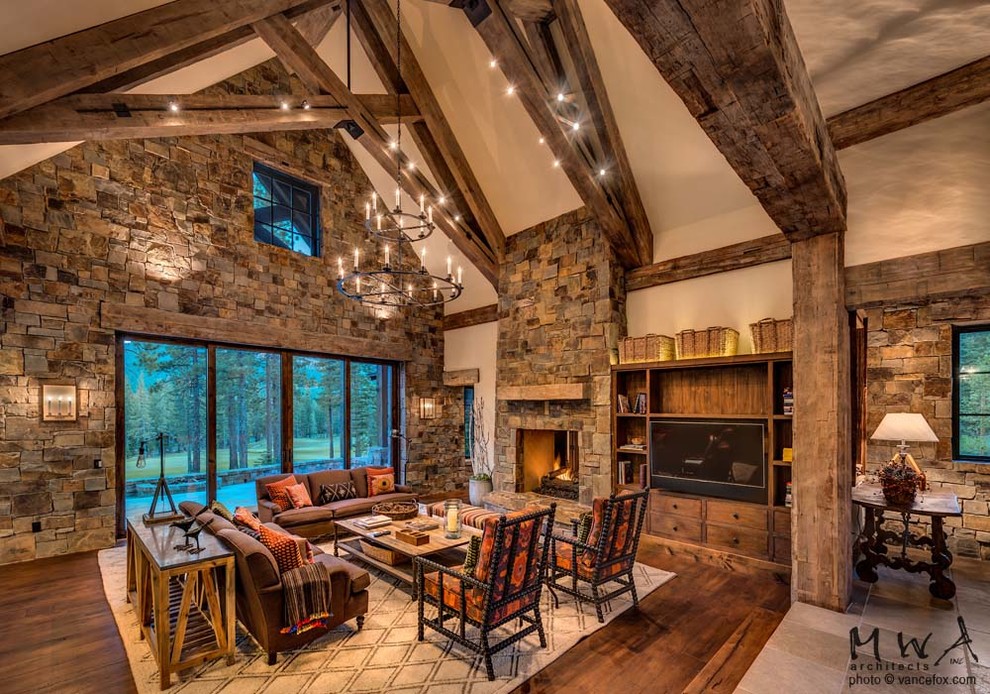 Large traditional formal open concept living room in Other with beige walls, medium hardwood floors, a two-sided fireplace, a stone fireplace surround, a built-in media wall and brown floor.