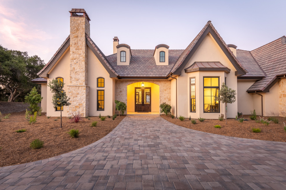 Inspiration for an expansive two-storey beige house exterior in Other with stone veneer and a tile roof.