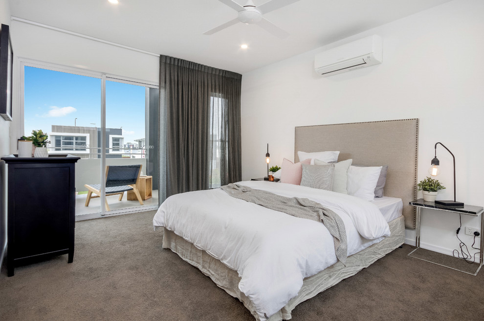 This is an example of a large modern master bedroom in Sunshine Coast with white walls and carpet.