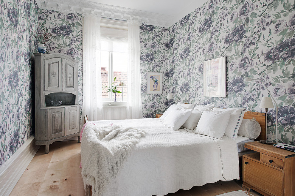 Mid-sized traditional master bedroom in Gothenburg with multi-coloured walls, light hardwood floors and no fireplace.