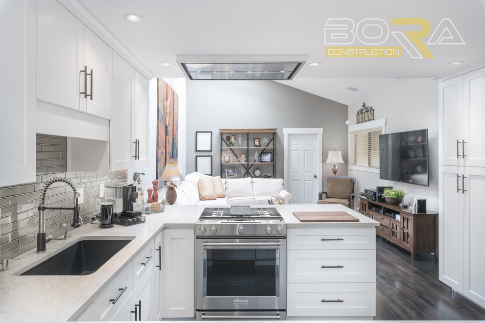 Mid-sized transitional u-shaped dark wood floor and brown floor eat-in kitchen photo with an undermount sink, recessed-panel cabinets, white cabinets, wood countertops, metallic backsplash, ceramic backsplash, stainless steel appliances and a peninsula