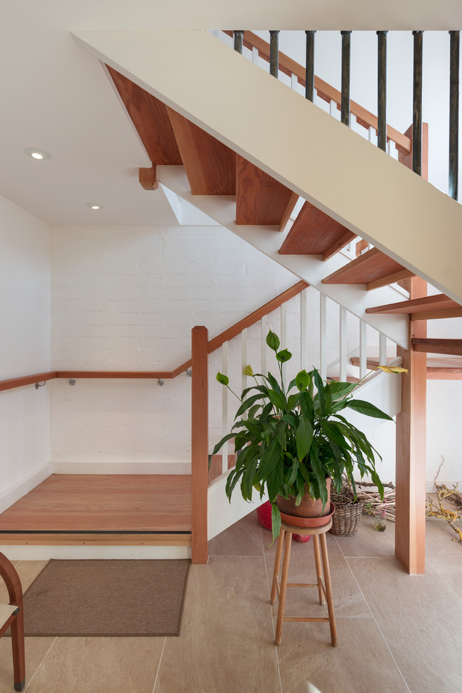 Large contemporary wood staircase in Devon with open risers and wood railing.
