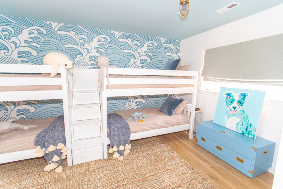 Exemple d'une grande chambre d'enfant de 4 à 10 ans bord de mer avec un mur bleu, parquet clair et du papier peint.