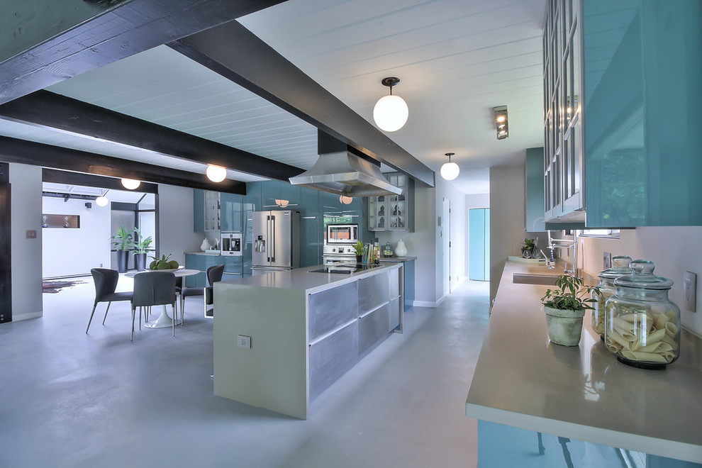 Large midcentury l-shaped eat-in kitchen in Other with an undermount sink, flat-panel cabinets, blue cabinets, quartz benchtops, stainless steel appliances, concrete floors, with island and grey floor.