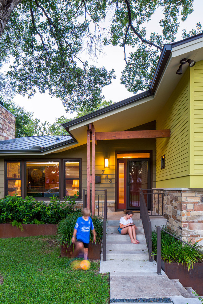 This is an example of a mid-sized contemporary split-level green exterior in Austin with concrete fiberboard siding and a gable roof.