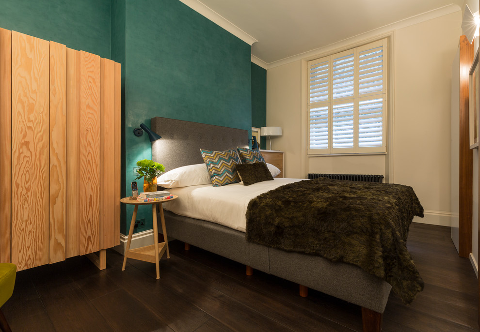 Inspiration for a mid-sized contemporary bedroom in London with blue walls and dark hardwood floors.