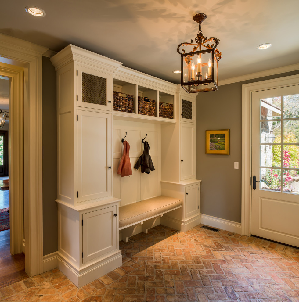 Photo of a large traditional mudroom in Philadelphia with brick floors, grey walls, a single front door and a white front door.