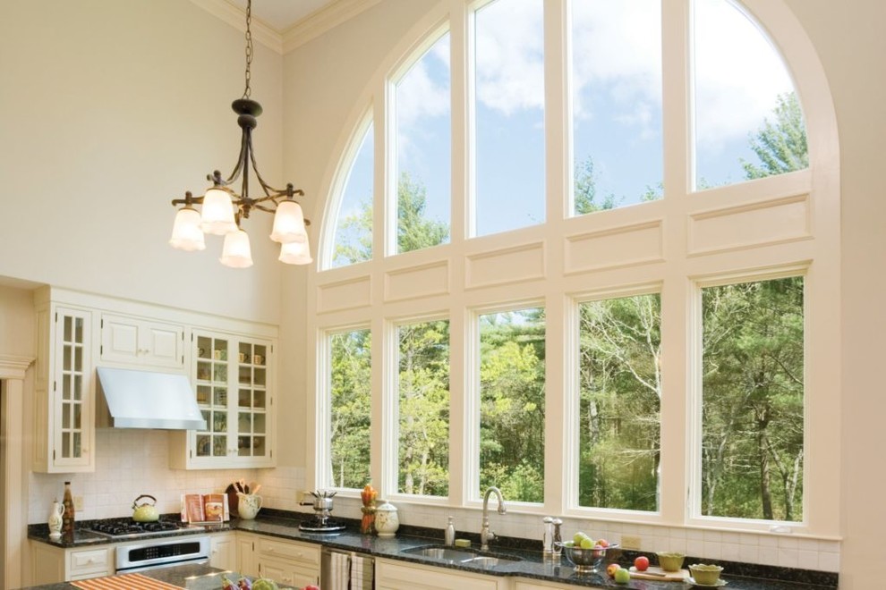 Example of a large transitional l-shaped open concept kitchen design in Cedar Rapids with a double-bowl sink, glass-front cabinets, white cabinets, solid surface countertops, stainless steel appliances and an island