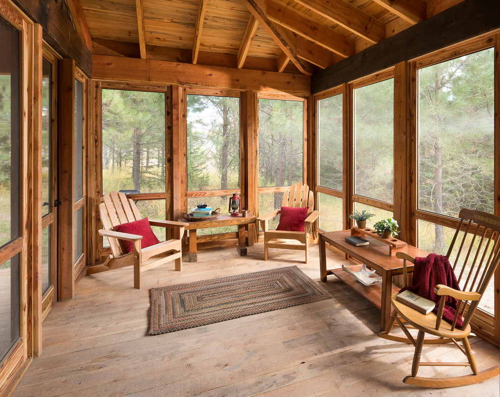 Inspiration for a mid-sized rustic screened-in front porch remodel in Other with decking and a roof extension