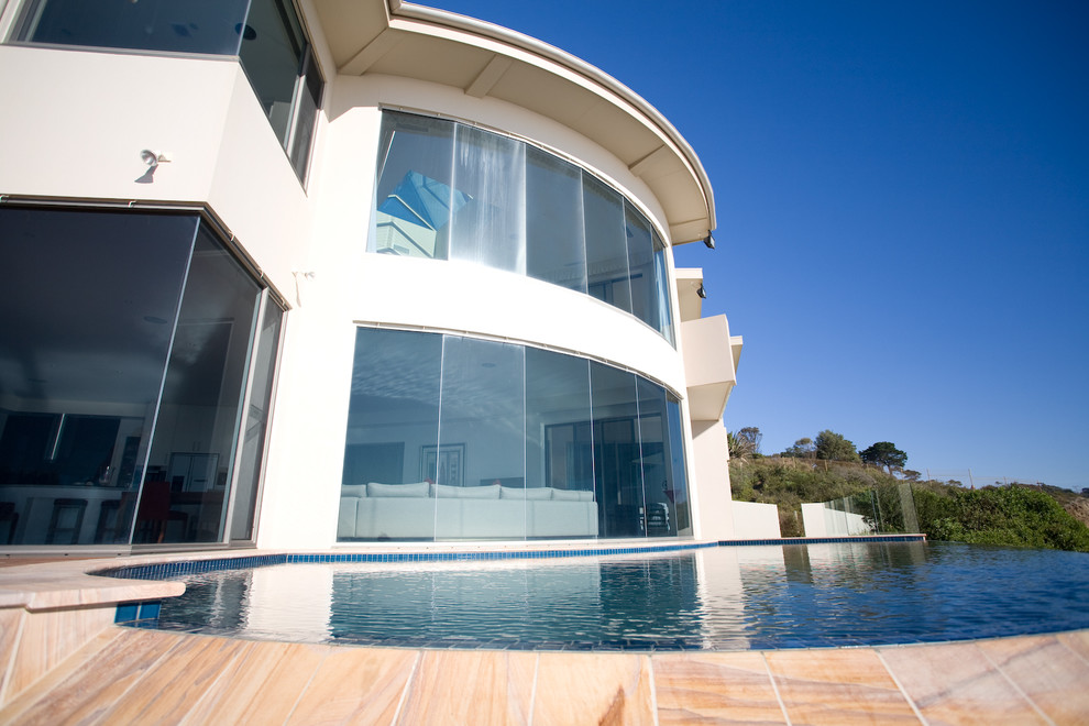 Inspiration for a small beach style backyard custom-shaped aboveground pool in Melbourne with decking.