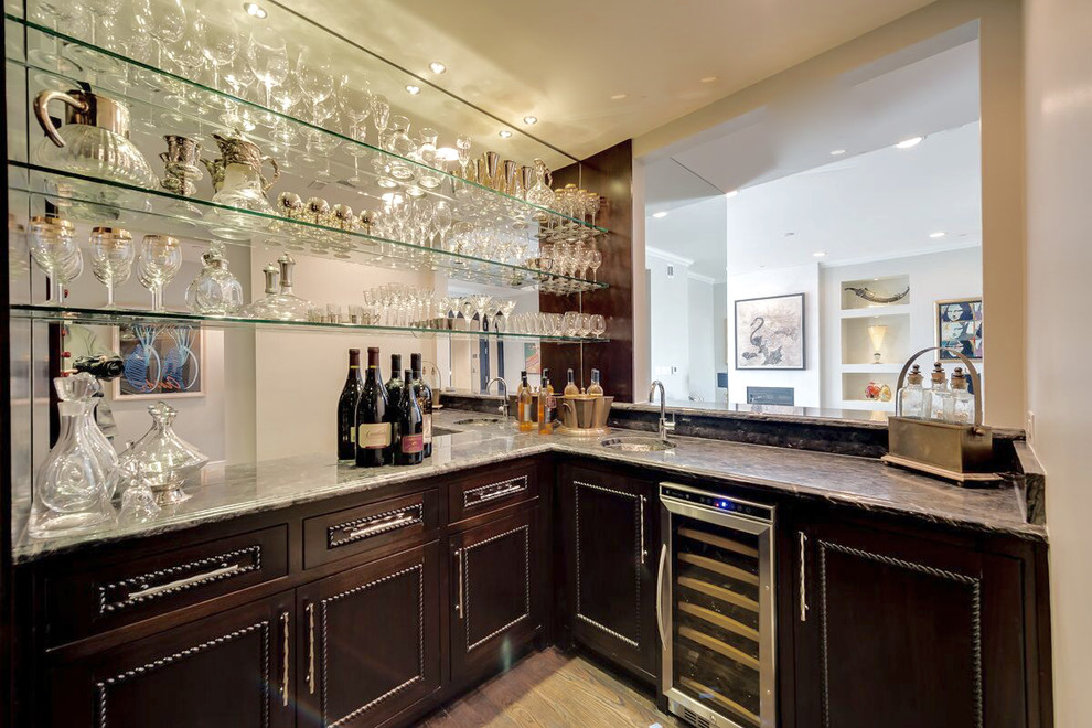 Design ideas for a large contemporary l-shaped wet bar in Dallas with an undermount sink, dark wood cabinets, light hardwood floors, beaded inset cabinets, marble benchtops, brown splashback, mirror splashback, brown floor and brown benchtop.