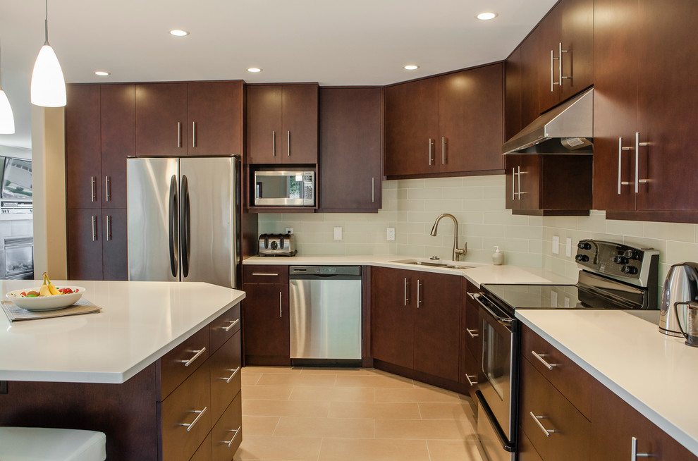 Photo of a contemporary u-shaped kitchen in Vancouver with an undermount sink, flat-panel cabinets, dark wood cabinets, granite benchtops, beige splashback, ceramic splashback, stainless steel appliances, ceramic floors and with island.