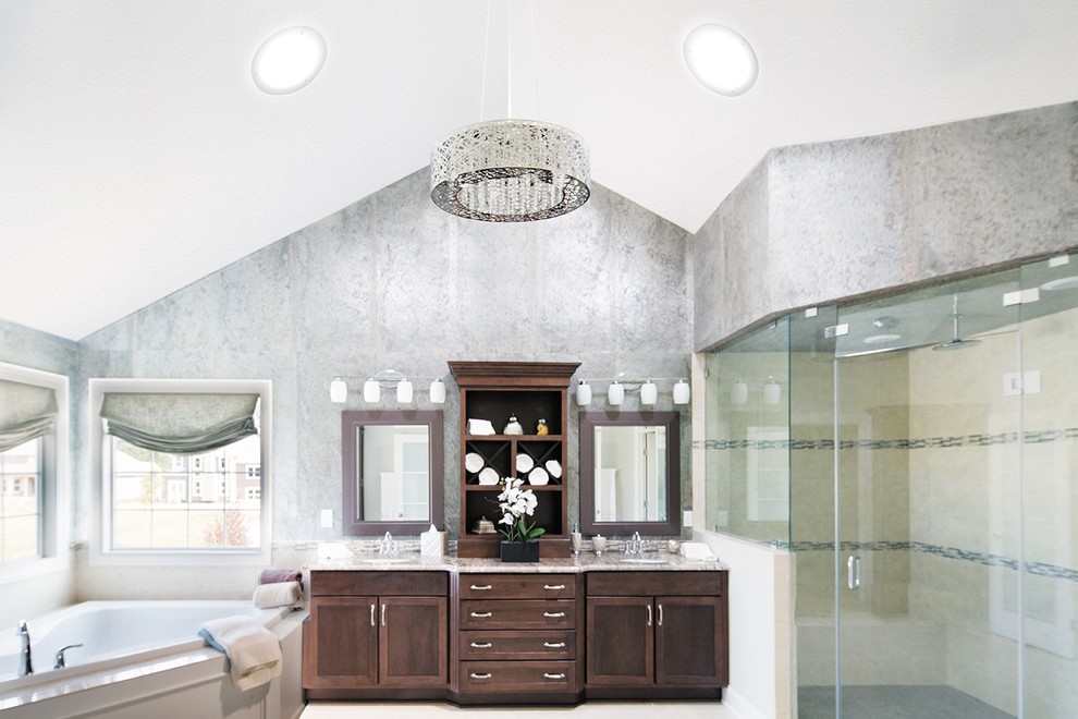 Large contemporary master bathroom in Austin with a wall-mount sink, flat-panel cabinets, dark wood cabinets, granite benchtops, a corner tub, an alcove shower, gray tile, porcelain tile, grey walls and porcelain floors.