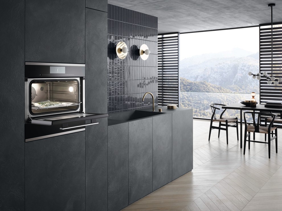This is an example of a contemporary kitchen in Moscow with black cabinets, light hardwood floors and beige floor.