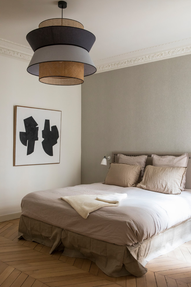 Inspiration for a transitional bedroom in Paris with grey walls, medium hardwood floors and brown floor.