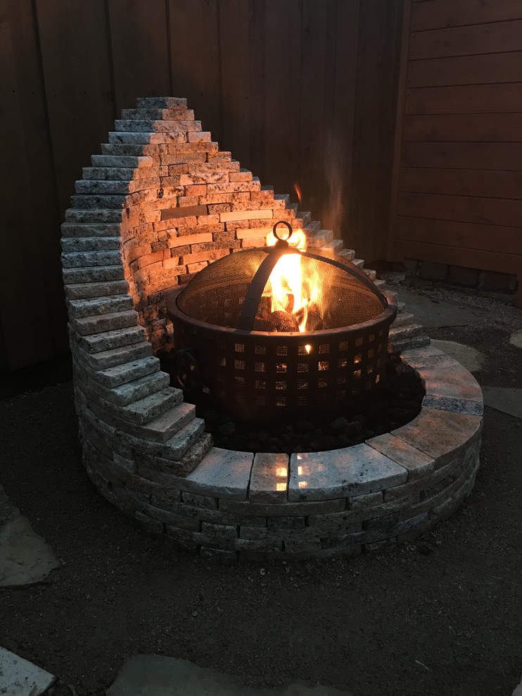 Design ideas for a mid-sized arts and crafts backyard patio in Dallas with a fire feature, natural stone pavers and no cover.