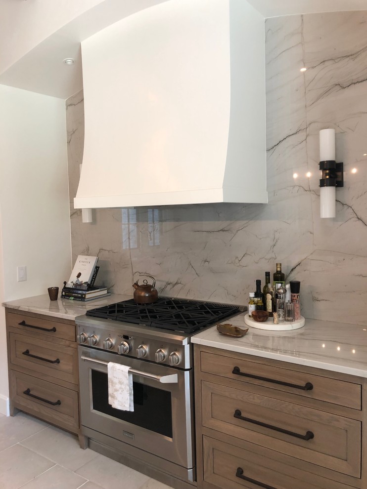 Large modern kitchen in Miami with a belfast sink, quartz worktops, white splashback, stone slab splashback, stainless steel appliances, an island, white floors and white worktops.