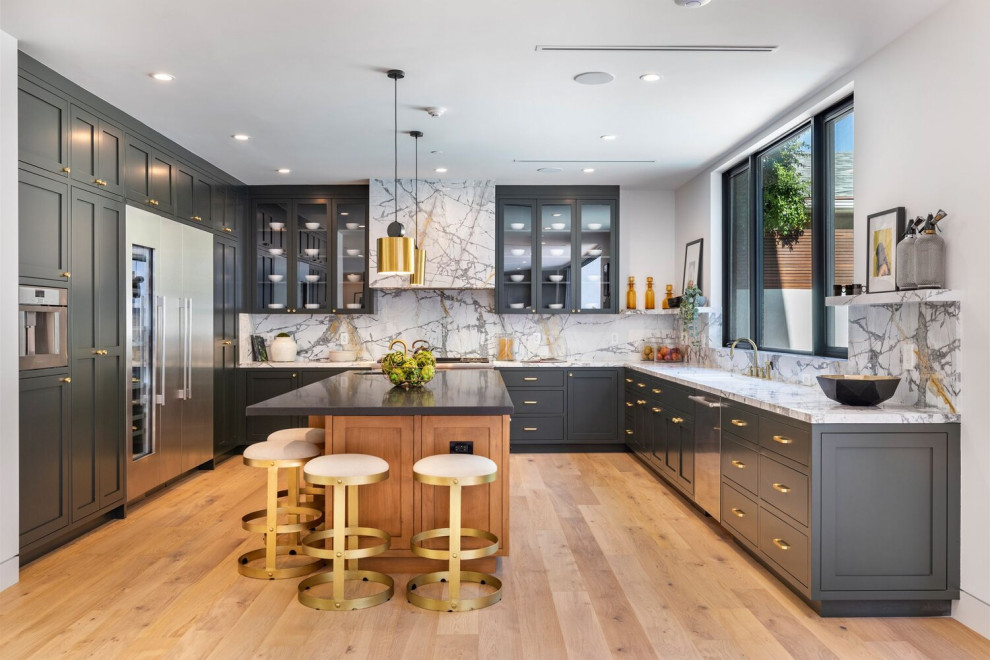 Design ideas for a large contemporary u-shaped eat-in kitchen in Los Angeles with an undermount sink, shaker cabinets, grey cabinets, marble benchtops, white splashback, marble splashback, stainless steel appliances, light hardwood floors, with island, beige floor and white benchtop.
