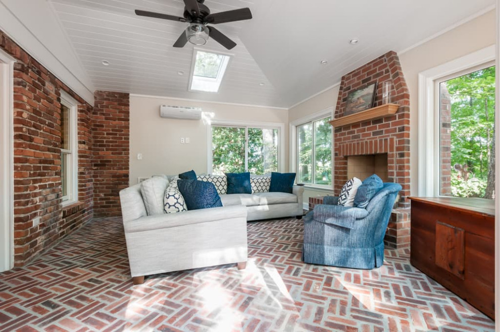 Photo of a large traditional sunroom in Atlanta with brick floors, a standard fireplace, a brick fireplace surround, a skylight and red floor.