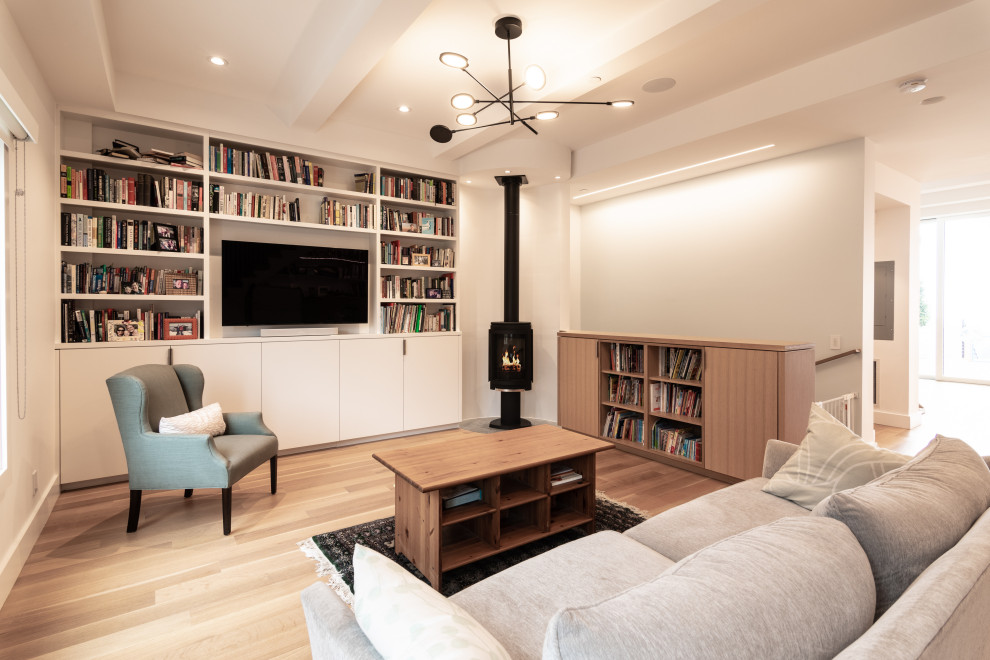 Inspiration for a mid-sized transitional open concept living room in San Francisco with a library, medium hardwood floors, a wood stove, a built-in media wall, brown floor and coffered.