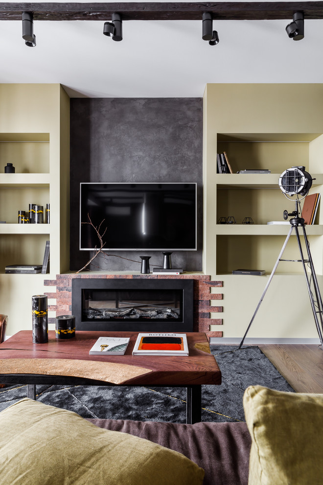 Photo of a mid-sized industrial loft-style living room in Other with a library, brown walls, porcelain floors, a ribbon fireplace, a brick fireplace surround, a wall-mounted tv and grey floor.