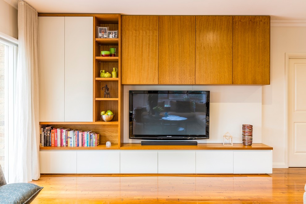 This is an example of a large contemporary open concept living room in Melbourne with white walls, medium hardwood floors, no fireplace and a wall-mounted tv.