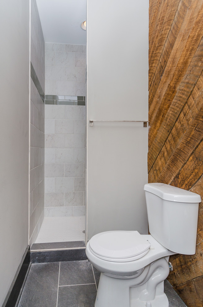 Design ideas for a mid-sized industrial 3/4 bathroom in Baltimore with an alcove shower, a two-piece toilet, gray tile, beige walls, slate floors and a pedestal sink.