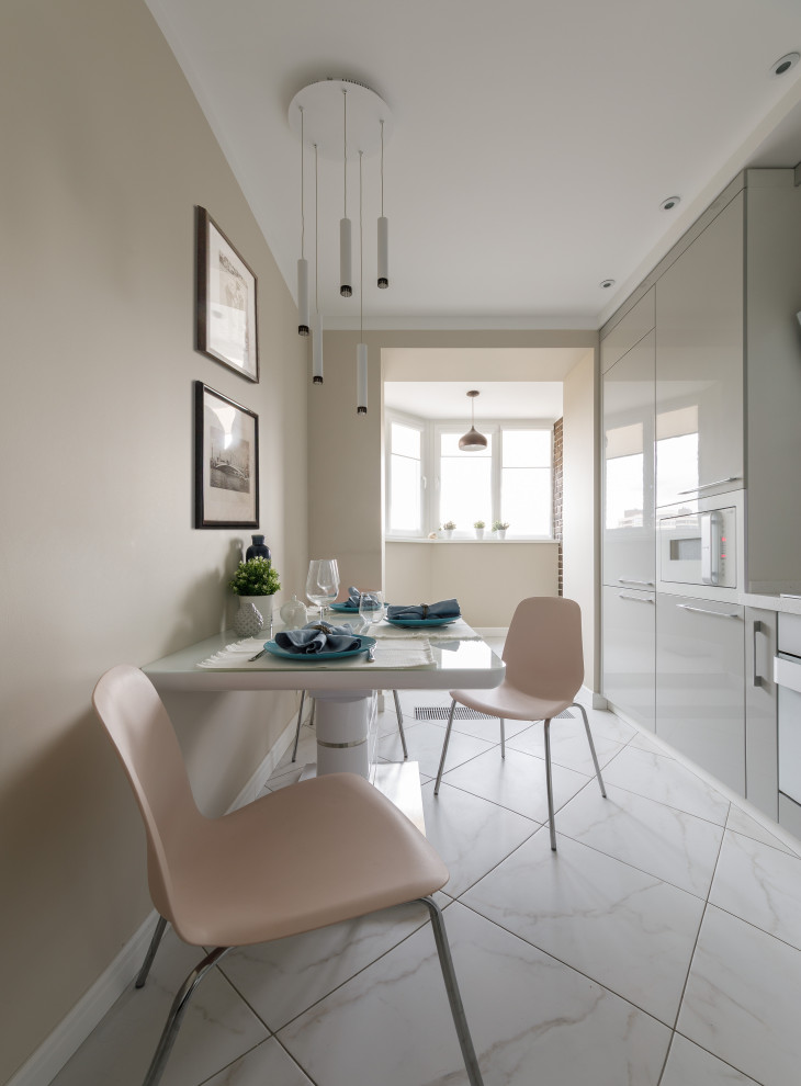Small contemporary l-shaped enclosed kitchen in Moscow with a submerged sink, flat-panel cabinets, grey cabinets, composite countertops, white splashback, ceramic splashback, white appliances, porcelain flooring, white floors and white worktops.