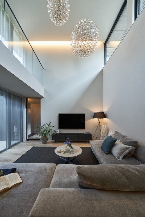 吹き抜けにきらめく照明器具が浮かぶ 柔らかな色彩でまとめたラグジュアリーな住まい Houzz ハウズ