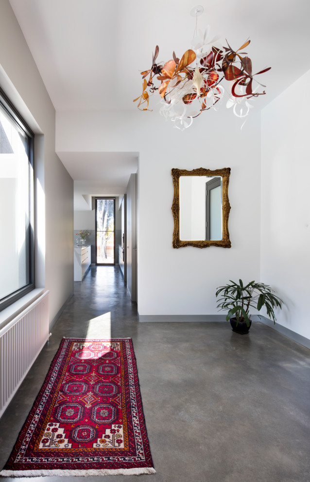 Inspiration for a mid-sized contemporary entry hall in Melbourne with white walls, concrete floors and grey floor.
