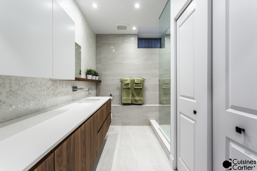 This is an example of a mid-sized contemporary 3/4 bathroom in Montreal with flat-panel cabinets, dark wood cabinets, a curbless shower, a one-piece toilet, white tile, mosaic tile, white walls, porcelain floors, an undermount sink and quartzite benchtops.