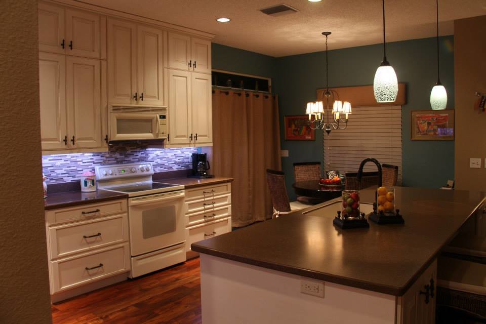 This is an example of a traditional l-shaped separate kitchen in Tampa with a single-bowl sink, recessed-panel cabinets, yellow cabinets, recycled glass benchtops, brown splashback, glass tile splashback and coloured appliances.
