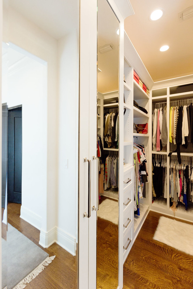 Inspiration for a mediterranean gender-neutral walk-in wardrobe in Orange County with shaker cabinets, white cabinets and medium hardwood floors.