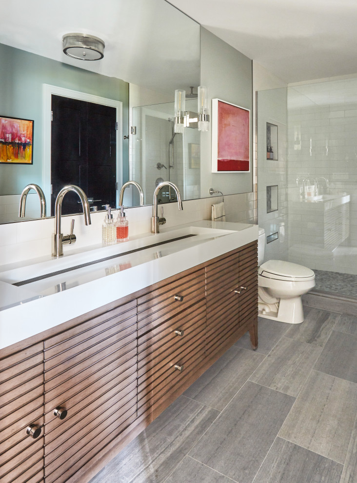 Photo of a small contemporary master bathroom in Chicago with furniture-like cabinets, brown cabinets, an alcove shower, a two-piece toilet, white tile, ceramic tile, white walls, porcelain floors, a trough sink, engineered quartz benchtops, grey floor, an open shower, white benchtops, a single vanity and a freestanding vanity.