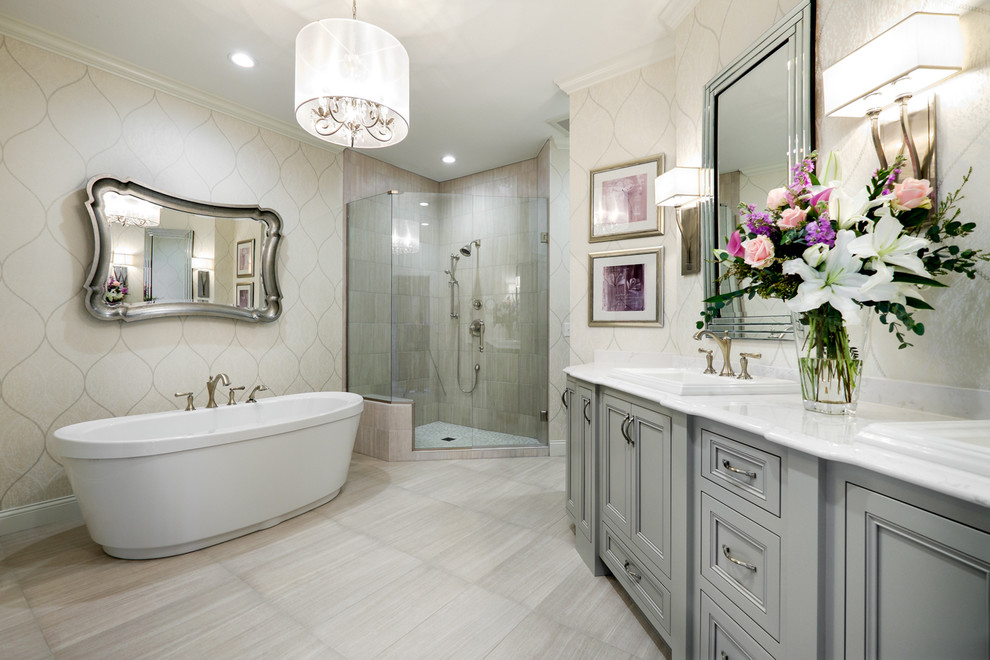 Large traditional master bathroom in Minneapolis with a drop-in sink, grey cabinets, engineered quartz benchtops, a freestanding tub, a corner shower, a one-piece toilet, gray tile, porcelain tile, grey walls, porcelain floors and recessed-panel cabinets.