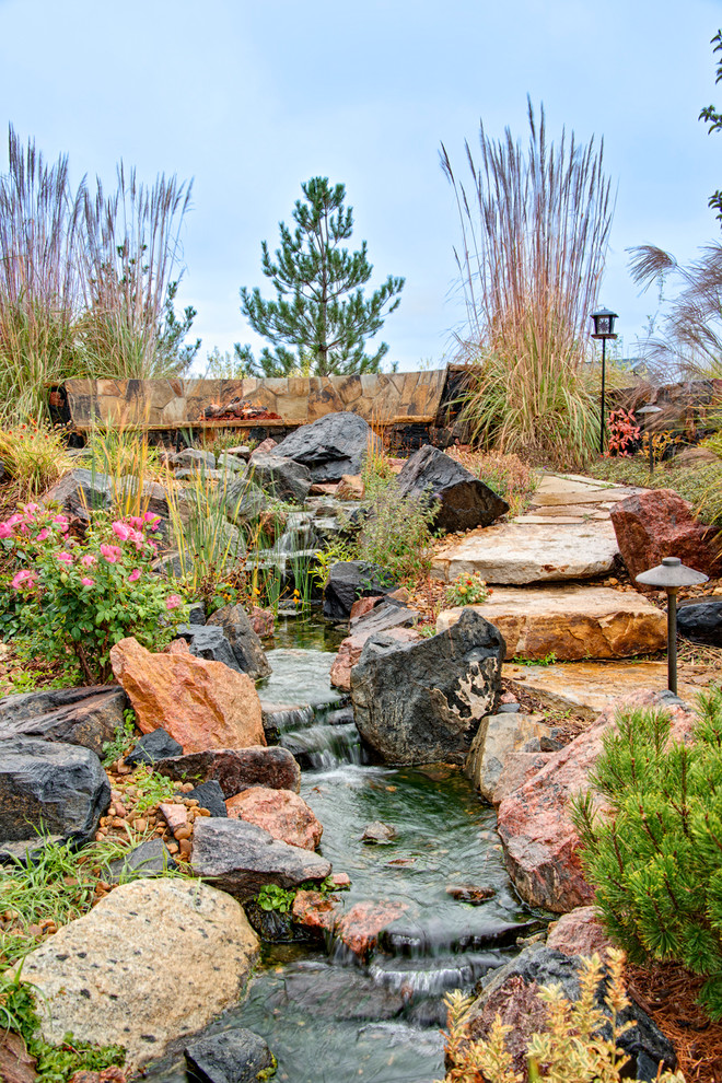 Design ideas for a mid-sized traditional backyard partial sun garden for spring in Denver with a water feature and natural stone pavers.