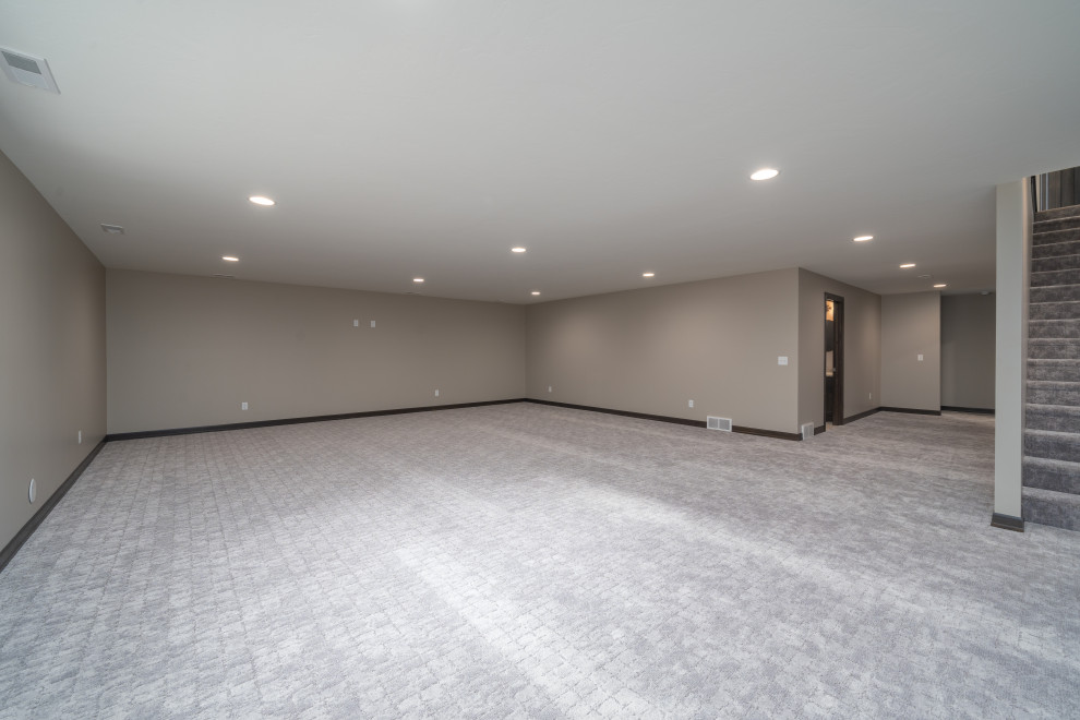 Transitional underground carpeted and gray floor basement photo with gray walls