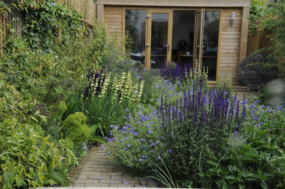 Photo of a small contemporary backyard partial sun garden in London with brick pavers.