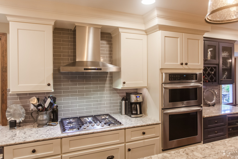 Inspiration for a large transitional single-wall dark wood floor, brown floor and coffered ceiling eat-in kitchen remodel in Cincinnati with a double-bowl sink, shaker cabinets, white cabinets, granite countertops, gray backsplash, subway tile backsplash, stainless steel appliances, an island and multicolored countertops