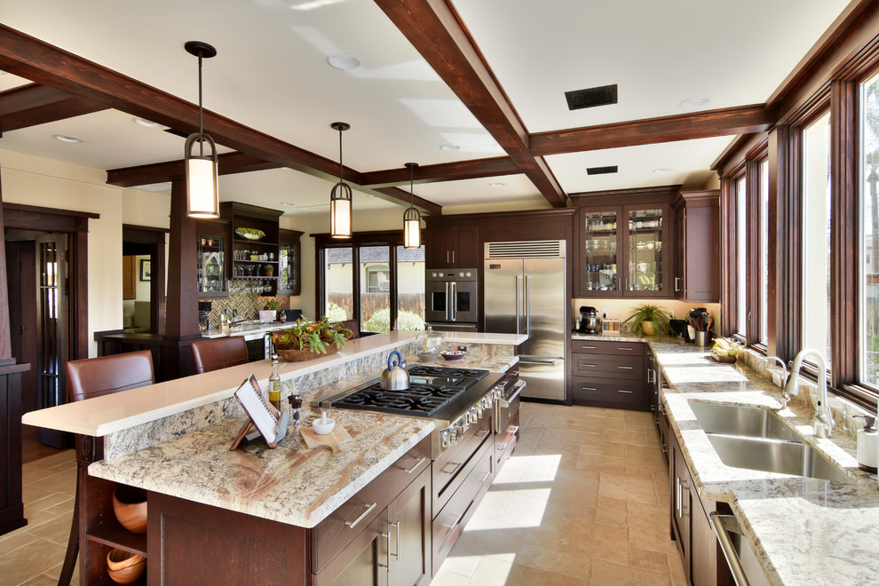 Photo of a large arts and crafts kitchen pantry in Phoenix with a double-bowl sink, shaker cabinets, brown cabinets, granite benchtops, stainless steel appliances, travertine floors and with island.