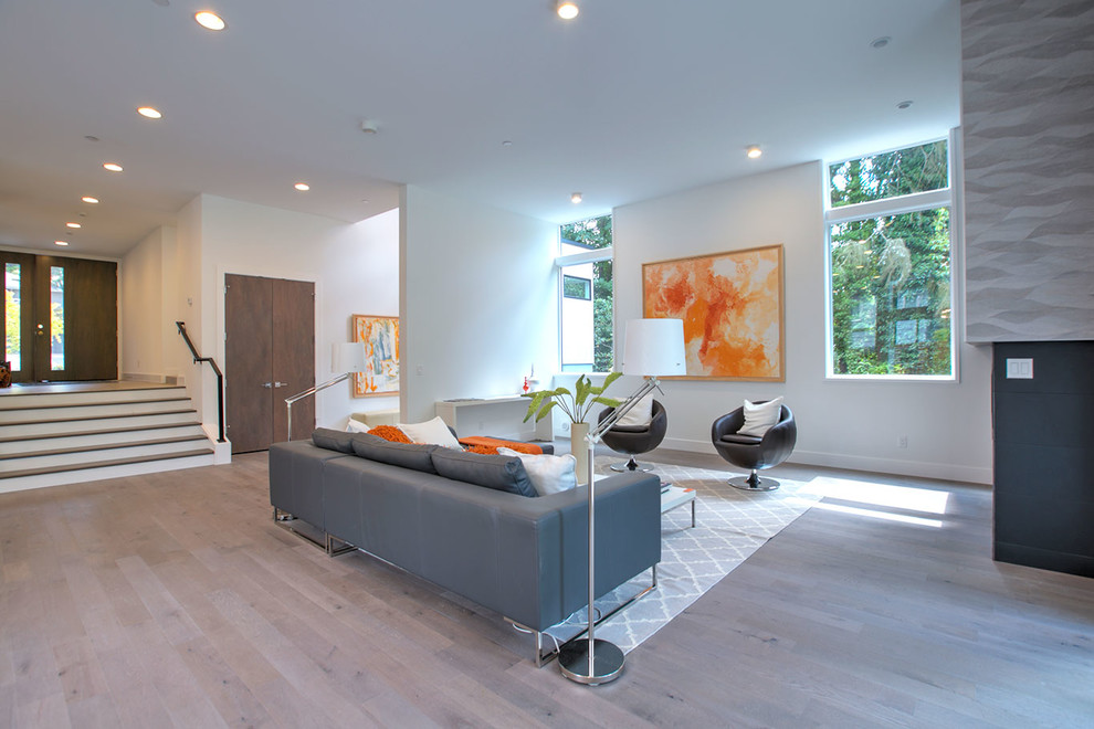 Inspiration for a mid-sized modern formal open concept living room in Seattle with white walls, medium hardwood floors, a ribbon fireplace, a tile fireplace surround, no tv and grey floor.