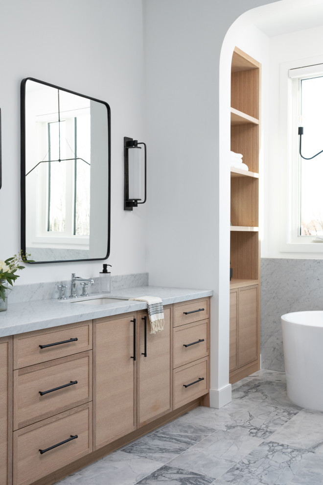 This is an example of a traditional bathroom in Other with shaker cabinets, black cabinets, a freestanding bath, a one-piece toilet, marble flooring, a submerged sink, marble worktops, grey floors, a hinged door, white worktops, double sinks and a built in vanity unit.
