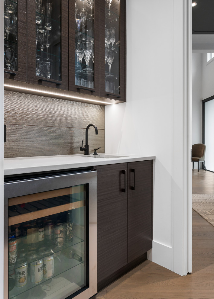 Inspiration for a small modern galley wet bar in Vancouver with a submerged sink, flat-panel cabinets, brown cabinets, quartz worktops, multi-coloured splashback, porcelain splashback, medium hardwood flooring and multicoloured worktops.
