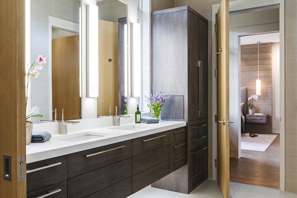 Photo of a contemporary bathroom in Other with flat-panel cabinets, dark wood cabinets, white tile, porcelain floors and an undermount sink.