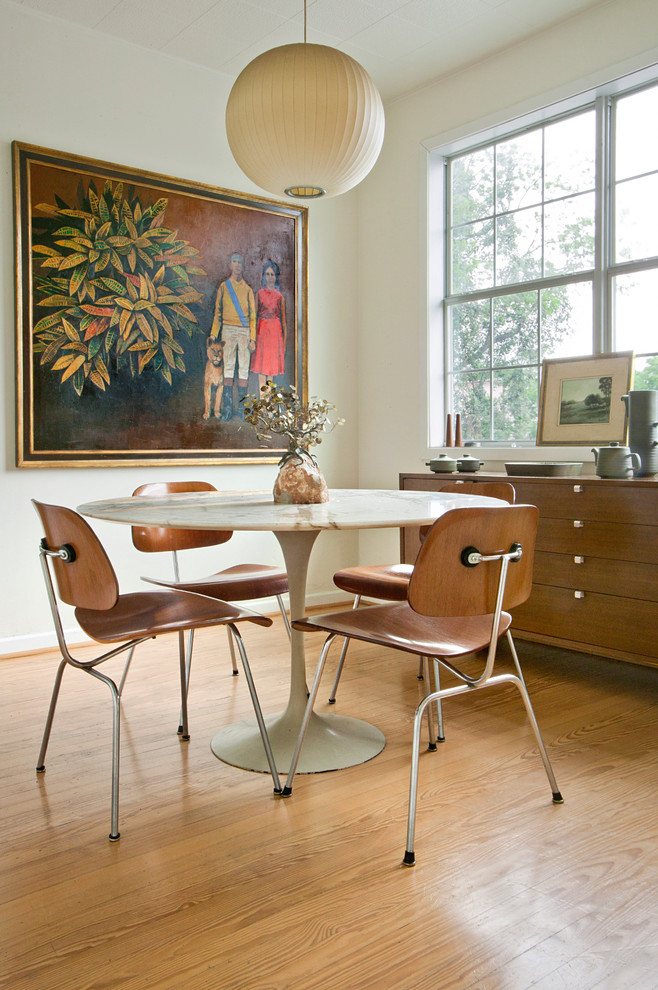 Photo of a midcentury dining room in Houston with white walls and medium hardwood floors.