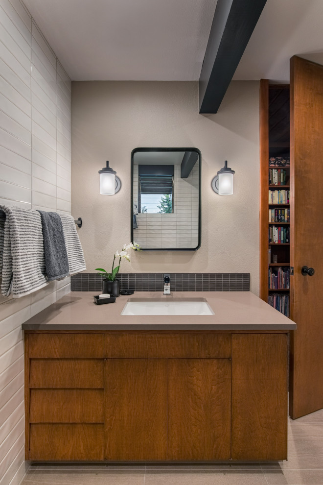 This is an example of a mid-sized midcentury bathroom in Portland with flat-panel cabinets, medium wood cabinets, white tile, ceramic tile, porcelain floors, an undermount sink, engineered quartz benchtops, beige floor, beige benchtops, a single vanity and a built-in vanity.