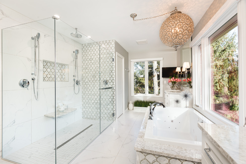 This is an example of a transitional bathroom in Detroit with a drop-in tub, a curbless shower, white tile, grey walls, white floor and a hinged shower door.