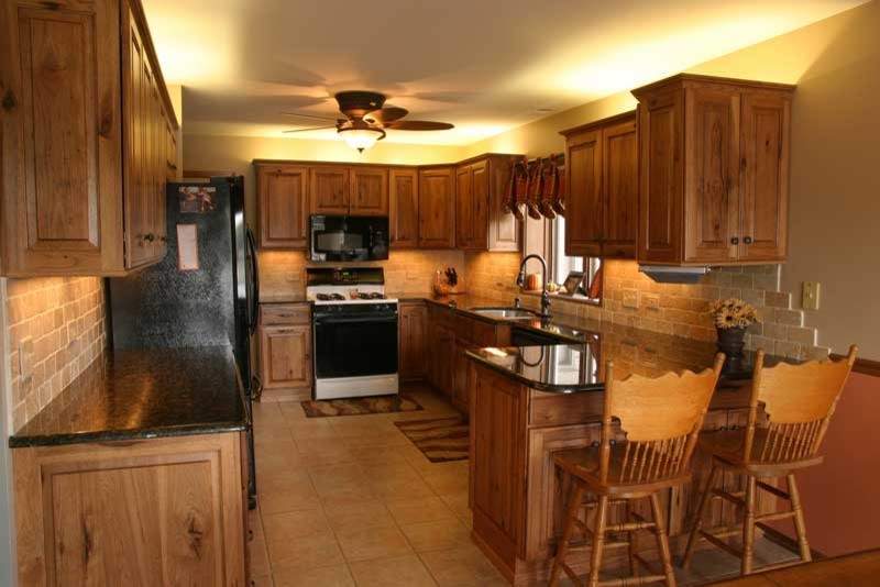 Inspiration for a transitional u-shaped medium tone wood floor kitchen pantry remodel in Chicago with raised-panel cabinets, medium tone wood cabinets and granite countertops